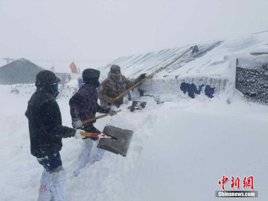 3月11日，西藏公安边防总队日喀则边防支队亚东大队康布边防派出所官兵为当地民众清理房屋积雪。 杜皓东 摄