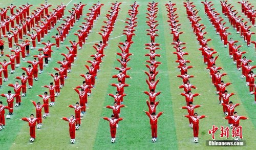 资料图：2016年11月2日，江西省德兴市某小学上千名小学生在操场上开心跳起足球舞。卓忠伟 摄