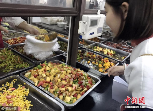 资料图：学生在校食堂窗口前买餐。图片来源：视觉中国
