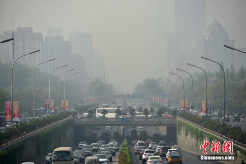 4月17日，北京迎来沙尘天气市区能见度降低，市民佩戴口罩出行。