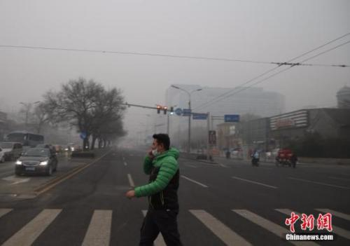 资料图：一名戴着口罩的行人走在北京街头。<a target='_blank' href='http://www.chinanews.com/'></table>中新社</a>记者 张浩 摄