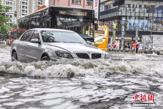 5月24日，广州江燕路，一辆汽车通过路段低洼积水处。陈骥旻 摄