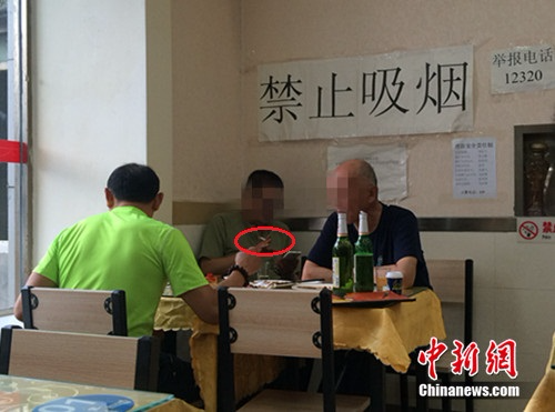 资料图：北京某餐馆，一男子在“禁止吸烟”的标识下抽烟。<a target='_blank' href='http://www.chinanews.com/' ></table>中新网</a> 邱宇 摄