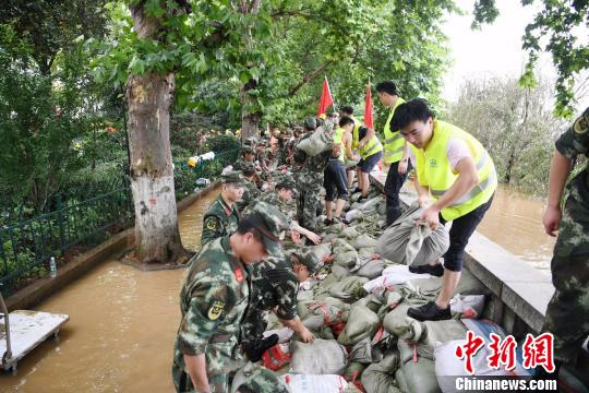 军民合力在湘江路风光带抢筑防洪堤。　杨华峰 摄