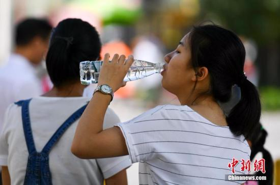 7月6日，新疆乌鲁木齐市最高温度达到36摄氏度，一位市民躲在阴凉处大口喝水。 <span target='_blank' href='http://www.chinanews.com/'></div>中新社</span>记者 刘新 摄
