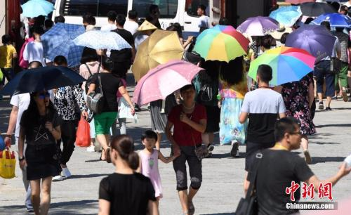 7月12日，厦门一景点游客们纷纷打起伞遮挡烈日。张斌 摄
