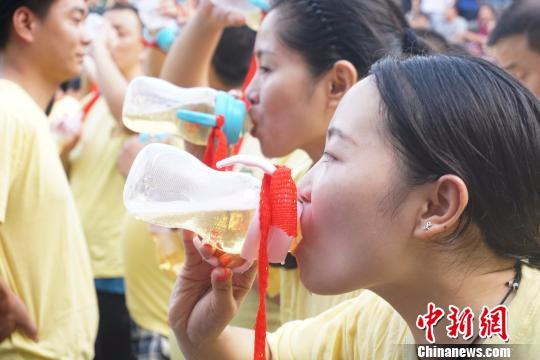 图为两名女游客手持奶瓶争分夺秒比赛喝啤酒。　贾亲亲　摄
