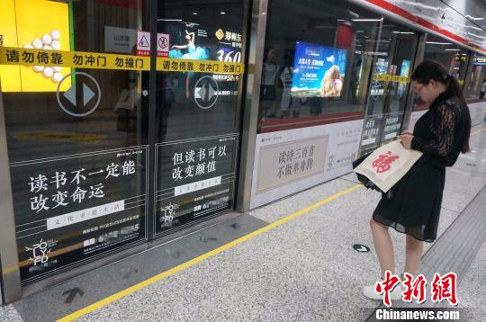 在人流如潮的地铁站里，与读书有关的广告显得别具一格。　韩章云 摄