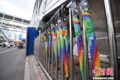 资料图：广西南宁一市民尝试取用共享雨伞。　俞靖 摄