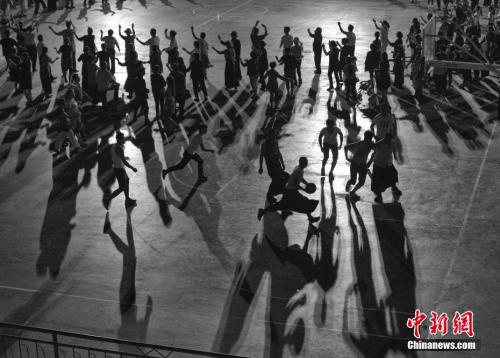 资料图：群众在跳广场舞，青年在一旁打篮球。 <a target='_blank' href='http://www.chinanews.com/'></table>中新社</a>记者 刘关关 摄