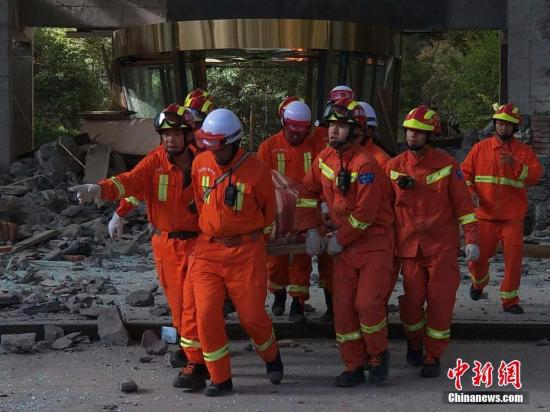 8月8日21时19分在四川阿坝州九寨沟县发生7.0级地震，震源深度20千米。图为8月9日，救援人员从受损建筑中救出一人。刘忠俊 摄