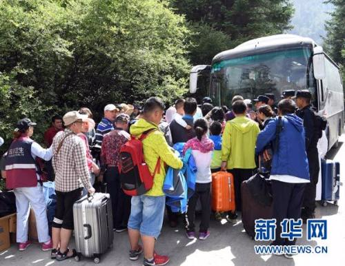 8月9日，在九寨天堂洲际大饭店，救援人员组织游客乘坐车辆撤离。新华社记者 范培珅 摄