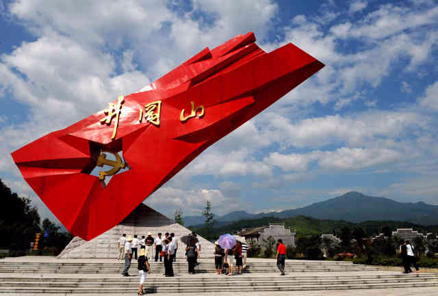 2009年6月30日,游客在井冈山的"井冈红旗"雕塑前参观.