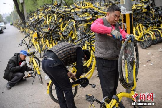 资料图：工作人员正在修理仍可修复的单车。 <a target='_blank' href='http://www.chinanews.com/'></table>中新社</a>记者 崔楠 摄