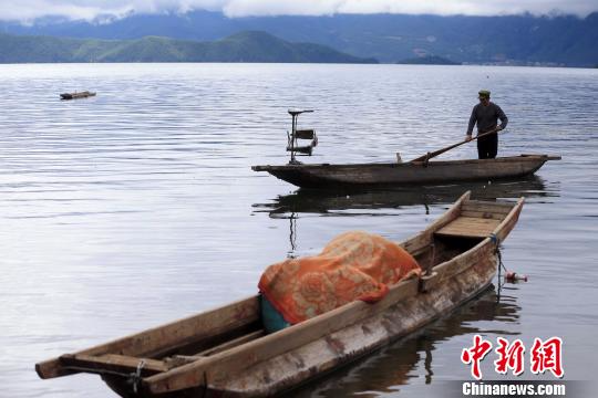 9月22日，一位摩梭渔民在泸沽湖上下网捕鱼。　王磊　摄
