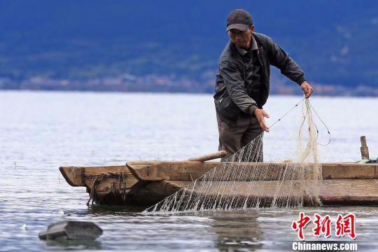 9月22日，一位摩梭渔民在泸沽湖上下网捕鱼。　王磊　摄