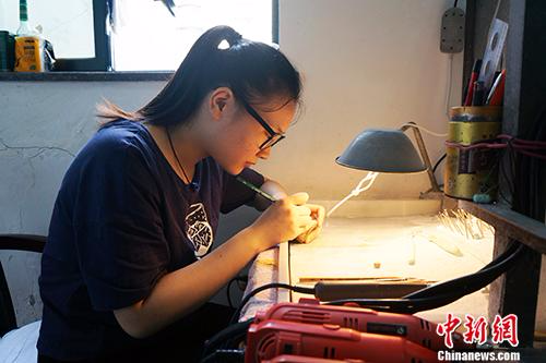 90后学徒廖青正在进行玉雕创作。汤琪 摄