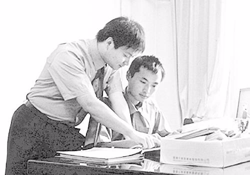 　　吕端冬(右)与同事一起探讨案情