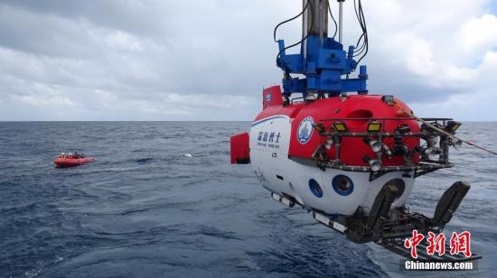 10月3日，“深海勇士”号载人深潜试验队在中国南海完成“深海勇士”号载人潜水器的全部海上试验。图为8月中旬拍摄的载人潜水器(右)和“蛙人”。 <a target='_blank' href='http://www.chinanews.com/'></table>中新社</a>记者 张素 摄