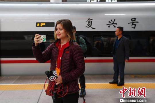 图为记者在抵达天津后，在车站与高铁列车“复兴号”合影留念。　富田 摄