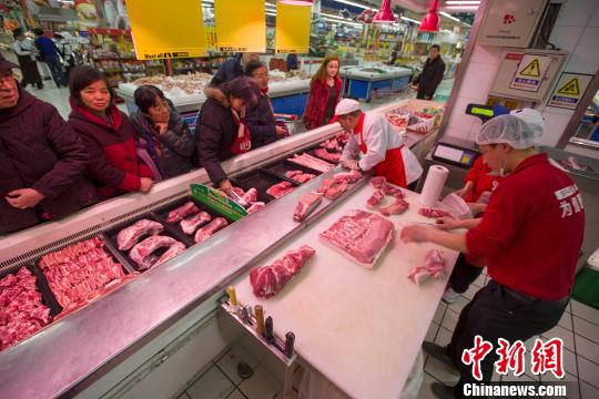 资料图：山西太原，超市员工在为民众分解猪肉。张云 摄