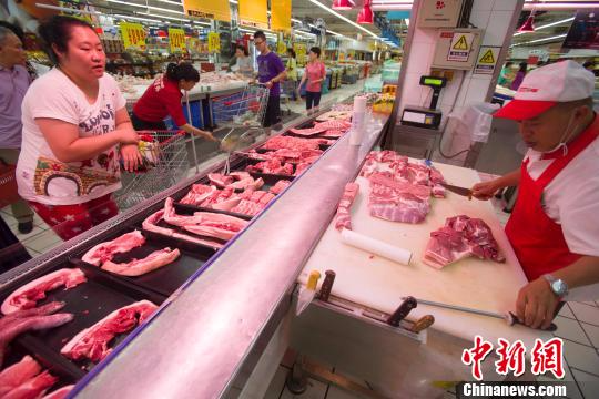 资料图：山西太原民众在超市选购猪肉。　张云　摄
