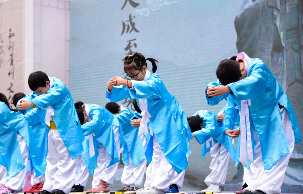11月24日，小学生们在活动现场表演“开笔礼”。