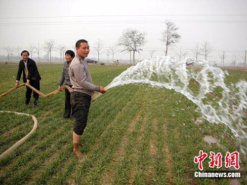 资料图：农民春节期间在田间浇麦抗旱。