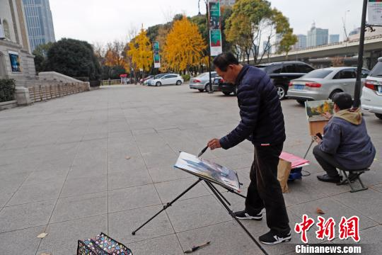 民众在上海音乐厅广场上绘画这美丽的场景。　殷立勤 摄