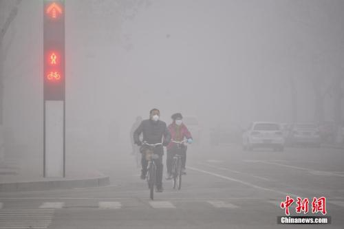 2016年2月12日，山东多地遭遇雾霾天气。市民在大雾笼罩下的山东省聊城市街头骑行。 图片来源：视觉中国