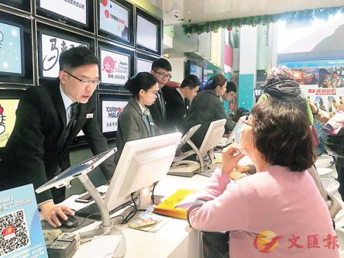 游客在旅行社咨询旅行团情况。图片来源：香港文汇报
