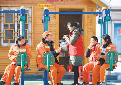 　　图为一月十日，安徽省肥西县环卫工人在“爱心小屋”前喝热水、晒太阳。新华社记者 刘军喜摄