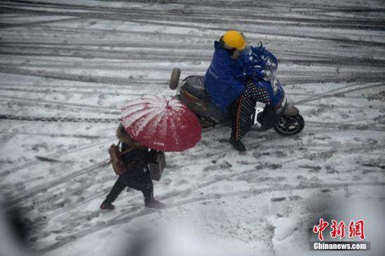 民众在结冰的道路上前行。 崔佳明 摄