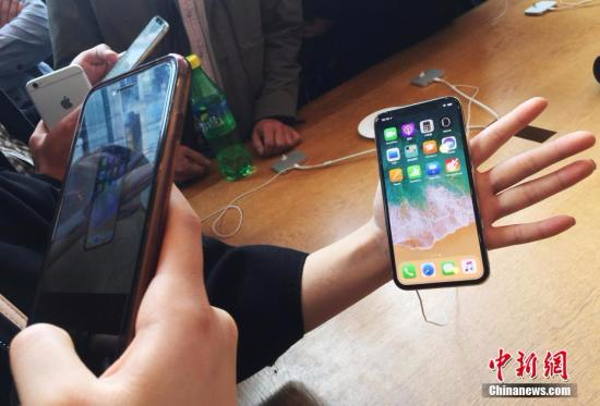 资料图：在上海南京东路的一家苹果直营店内，民众在拍摄iphoneX手机殷立勤 摄