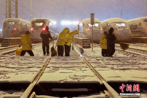 1月25日晚，在上海动车段南翔动车运用所，机械师们正加班加点，对高铁列车进行除冰融雪作业。张亨伟 摄