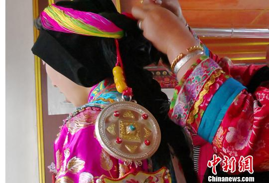 图为藏族阿妈为姑娘们打扮穿上节日盛装戴上藏饰。　南如卓玛 摄
