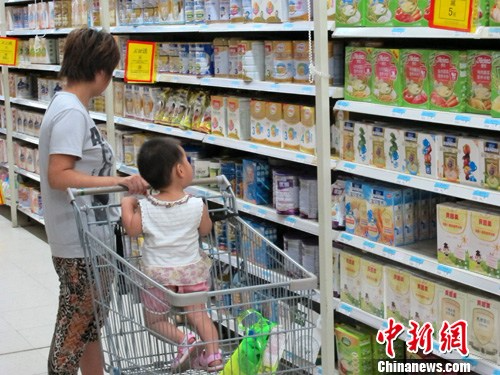 资料图：北京一大型超市内，一名市民带孩子挑选婴幼儿奶粉。<span target='_blank' href='http://www.chinanews.com/'>中新社</span>发 崔楠 摄