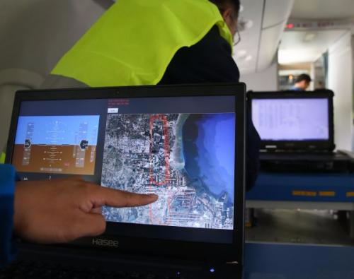 2017年10月14日，在ARJ21-700飞机103架机上，工作人员在展示通过北斗卫星定位系统获得的经纬度实时绘制的飞机飞行轨迹图。新华社记者 丁汀 摄