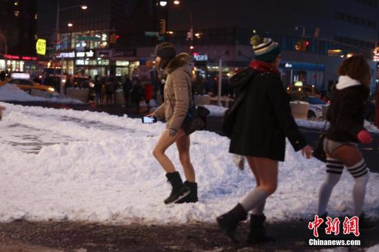 当地时间1月7日，纽约女子在曼哈顿的地铁里参加“不穿裤子搭地铁”活动时穿行雪地。 <a target='_blank' href='http://www.chinanews.com/'></table>中新社</a>记者 廖攀 摄