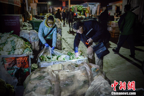 凌晨正在批发蔬菜的老丁。<span target='_blank' href='http://www.chinanews.com/' ></div>中新网</span>记者 富宇 摄