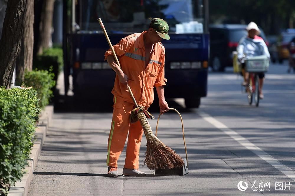 为了整洁的市容环境，环卫工人坚守在一线。（人民网记者 翁奇羽 摄）