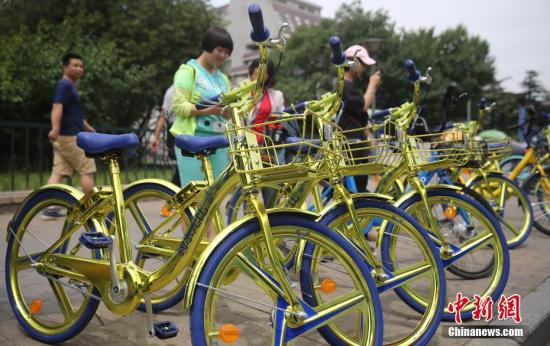 2017年6月8日，民众在北京街头扫码租用一款“土豪金”色的酷骑共享单车。 <a target='_blank' href='http://www.chinanews.com/'></table>中新社</a>记者 杨可佳 摄