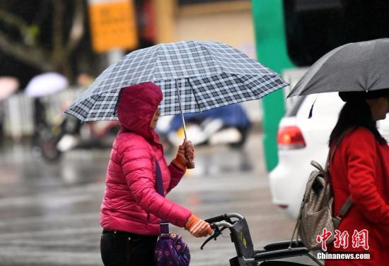 10月23日，昆明市区里身着羽绒服冒雨赶路的民众。 <a target='_blank' href='http://www.chinanews.com/'></table>中新社</a>记者 李进红 摄