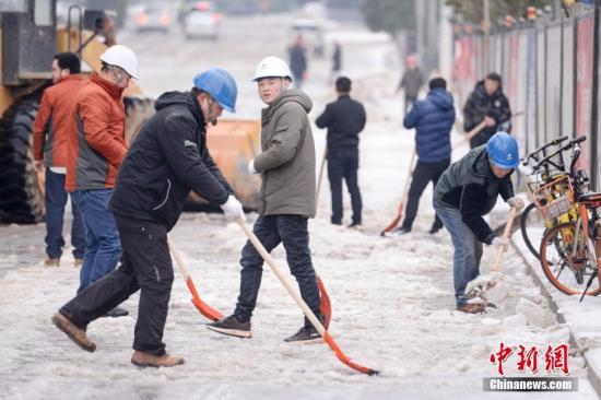 众多市民与工人参与到除冰铲雪中。 杨华峰 摄